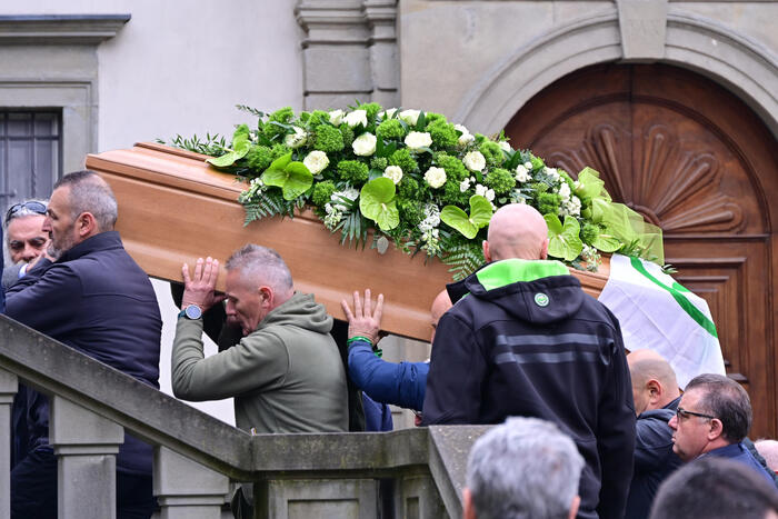 Funerale con bara ornata di fiori
